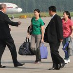 Journalists Laura Ling (in green shirt) and Euna Lee (in pink shirt) head to the plane after four months in North Korea prisons